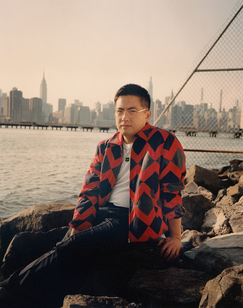 Bowen Yang wearing a Bode jacket, Sunspel T-shirt, Berluti pants, his own  glasses and jewelry 