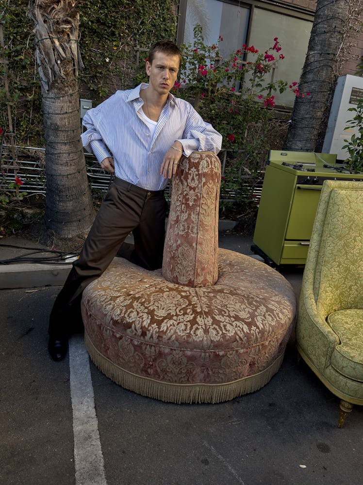 Harris Dickinson wears a Dolce & Gabbana shirt, tank top, and pants; Christian Louboutin shoes; his ...