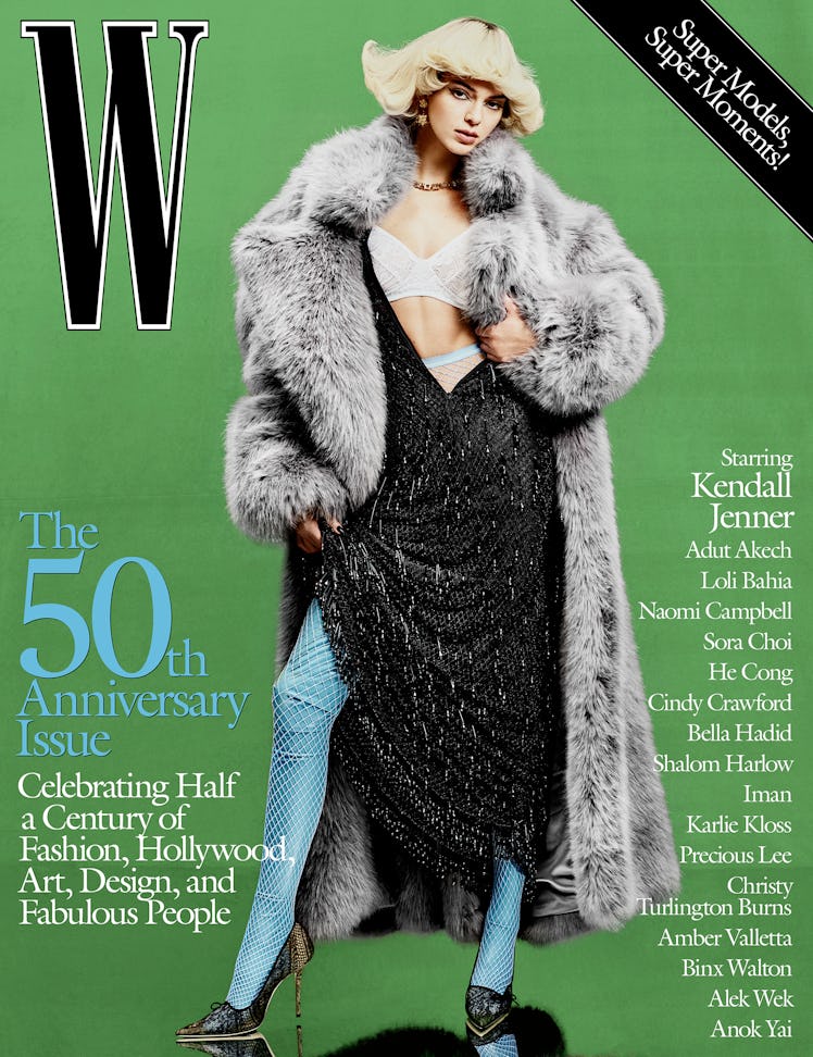Kendall Jenner on cover of W Magazine in a grey fur coat, black dress, and blue fishnets 