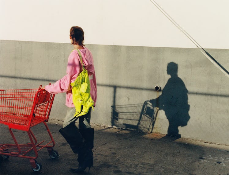 A model walks with a shopping cart