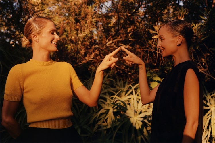 Paris Hilton wears a Prada sweater and skirt; her own earrings. Nicole Richie wears a Prada dress; h...